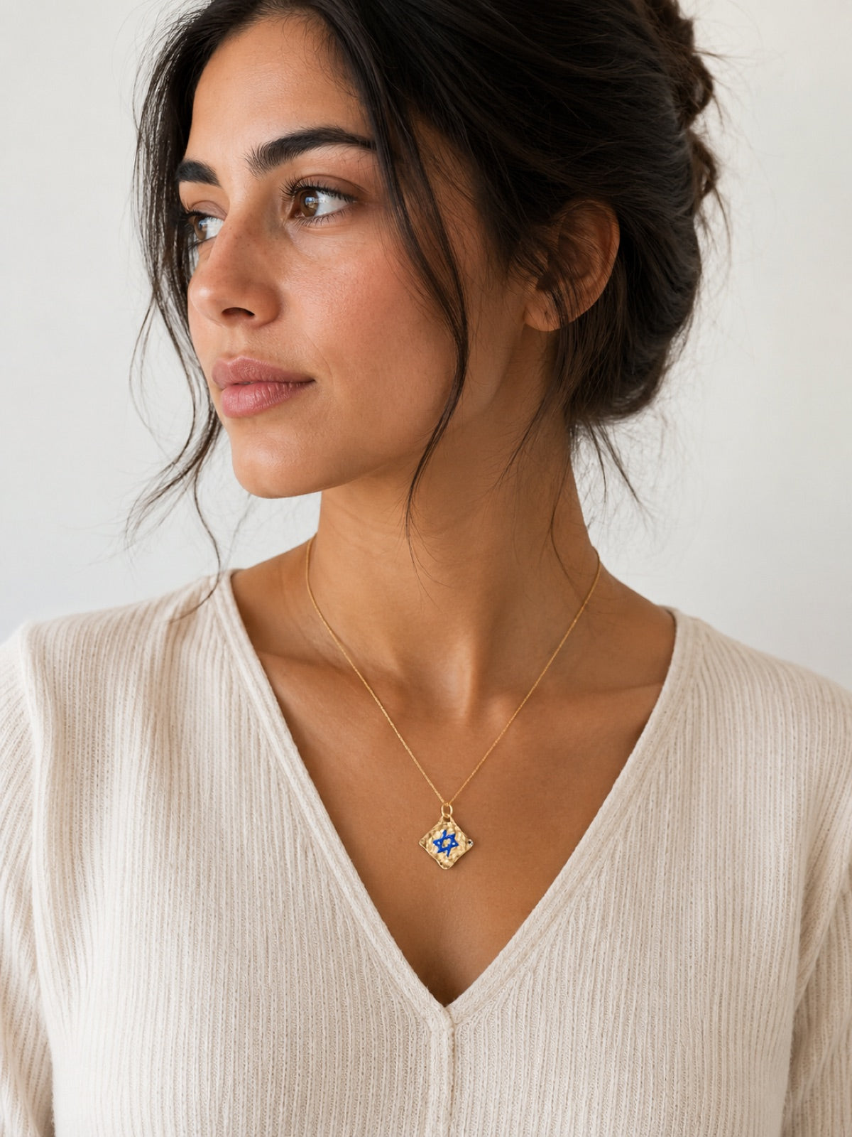 Female model wearing small square Magen David tag