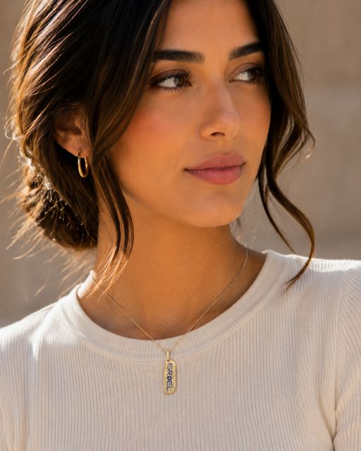 Rectangular tag in gold — on model